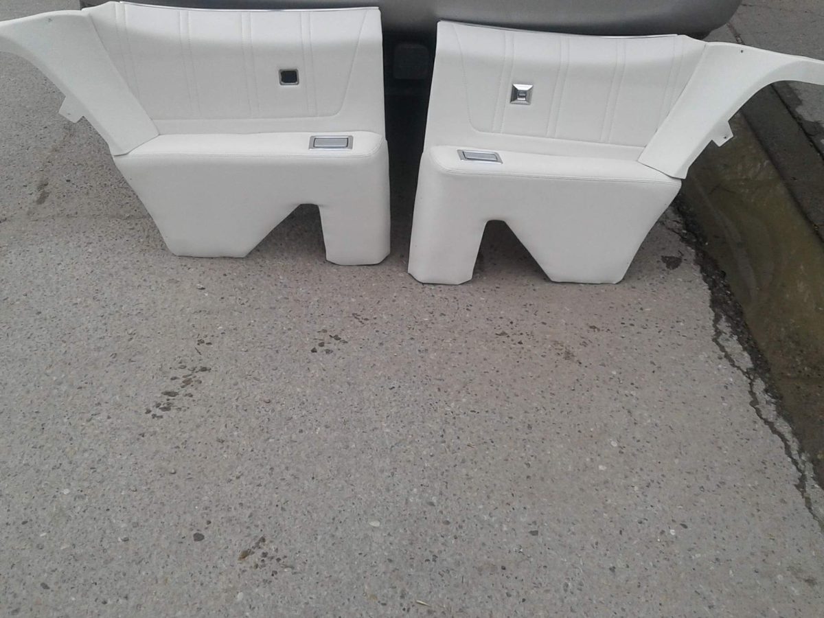 A pair of white door panels laid out on the ground after being recovered.